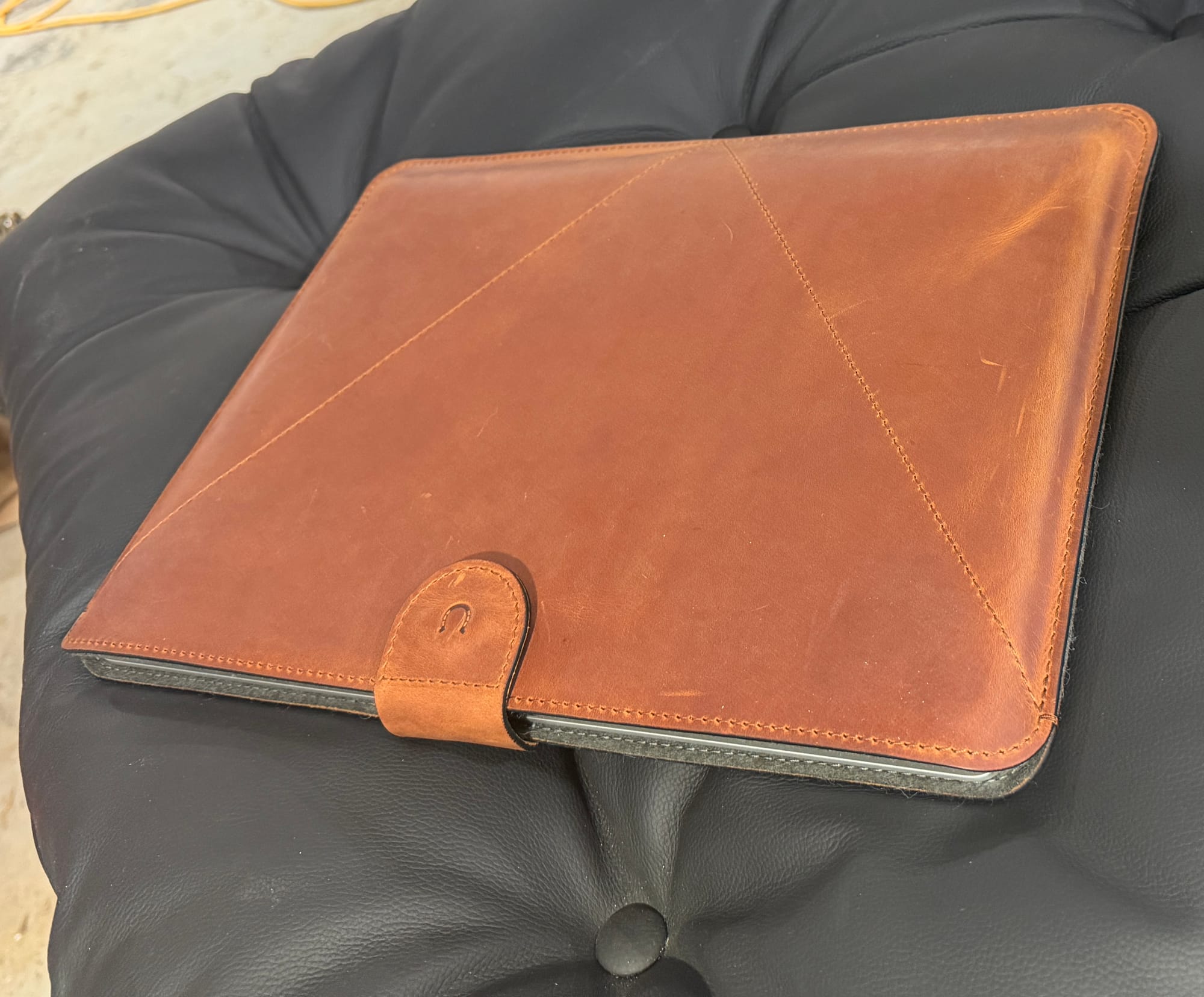 Angled view of the sleeve showing the envelope-style stitching pattern and the clasp tab