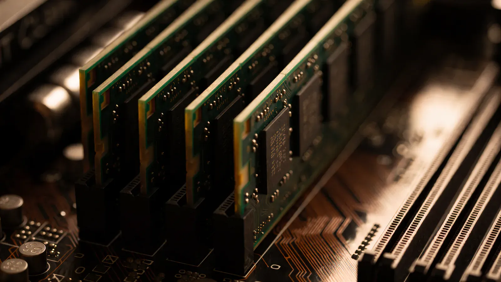 Macro photograph of four memory modules seated side by side in a dark motherboard